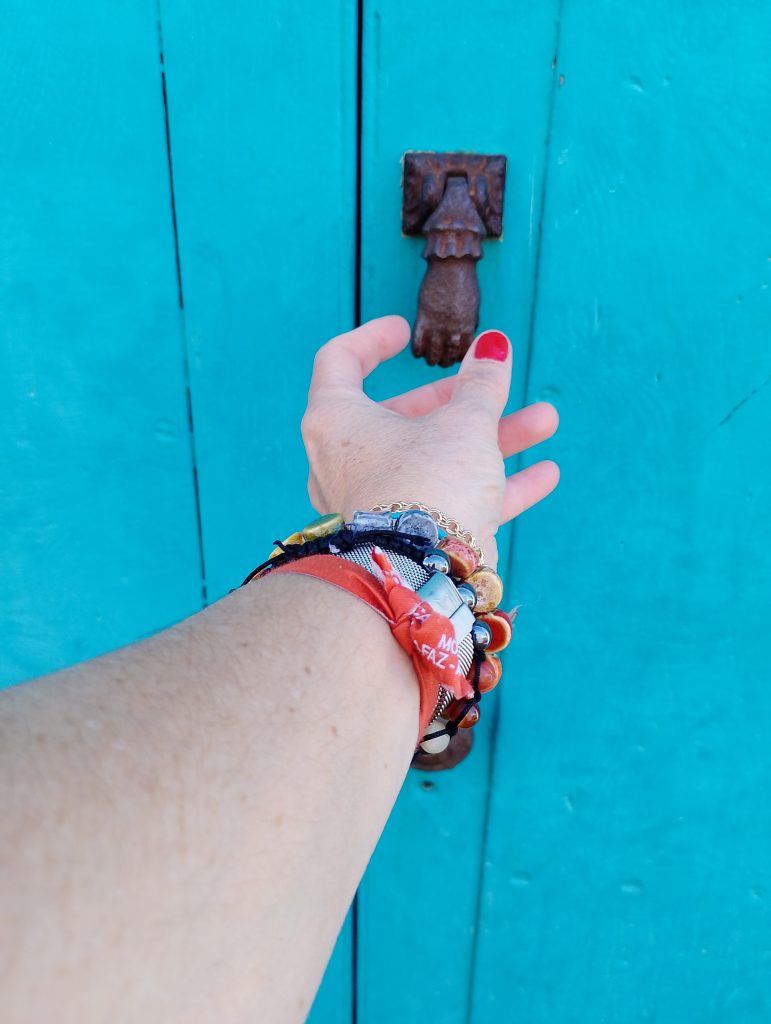 mano sosteniendo el pomo de una puerta azul, simbolizando el inicio de un nuevo rumbo con el Método Brújula